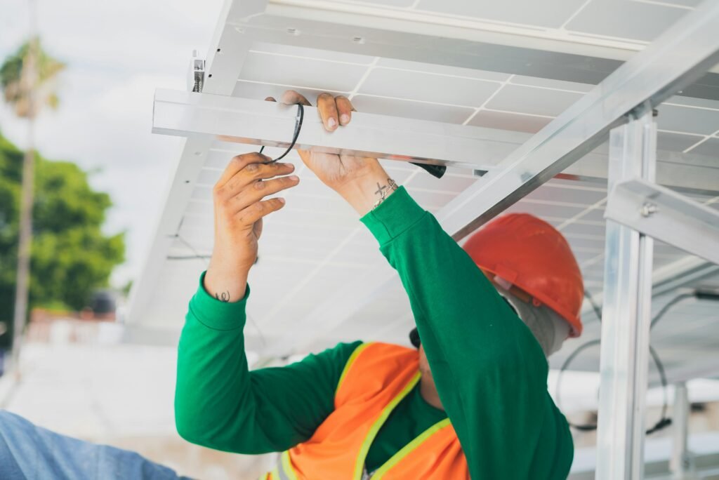 Commercial 2 A solar technician in PPE installs a solar panel, showcasing renewable energy work.